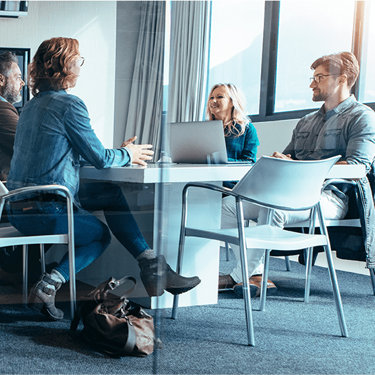 Professional SAP consulting team collaborating around a meeting table during an enterprise cloud software implementation strategy session.