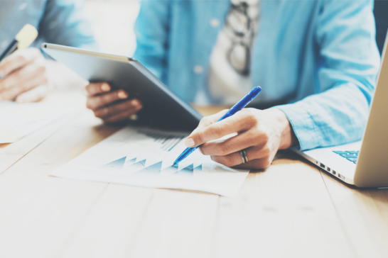 Business professional analyzing financial management charts and corporate data metrics on a tablet.